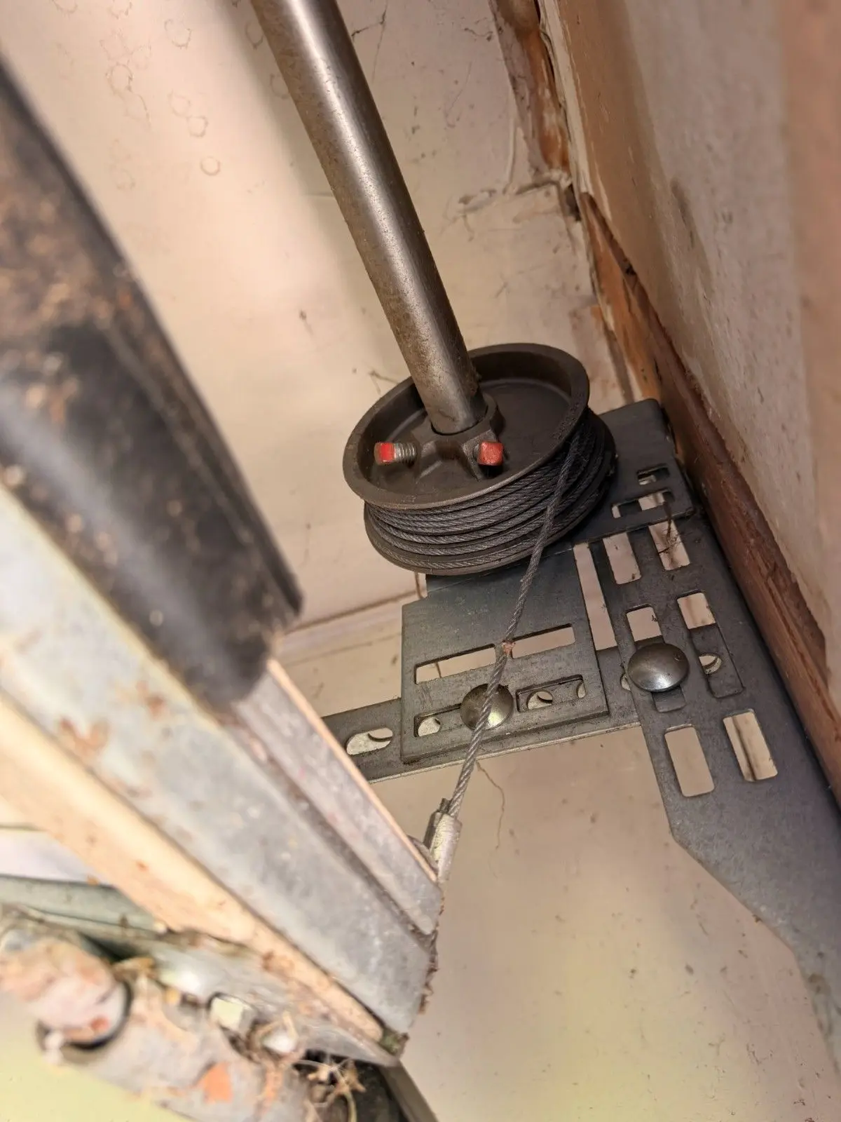 Cable drum and end bearing bracket at the end of a garage door torsion shaft