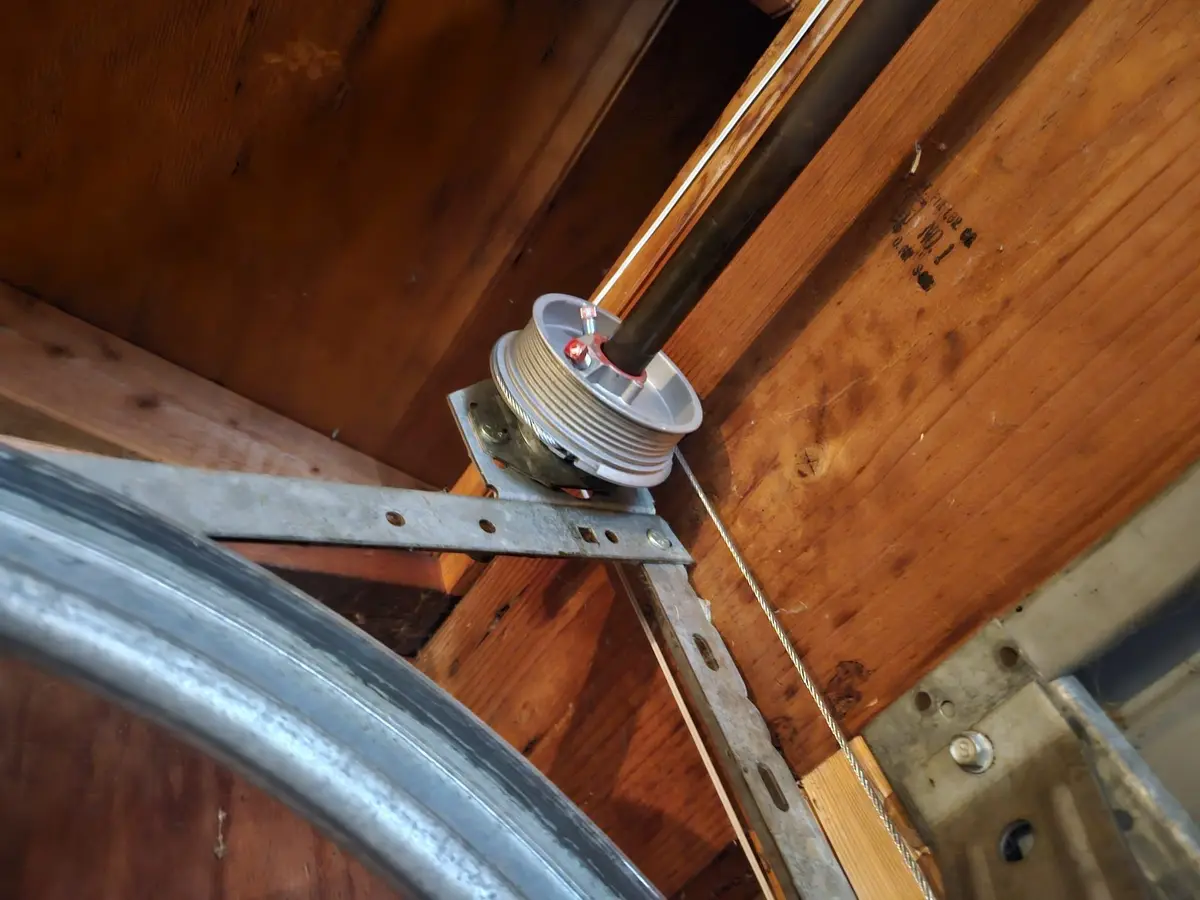 Garage door cable drum on its shaft above the curved track