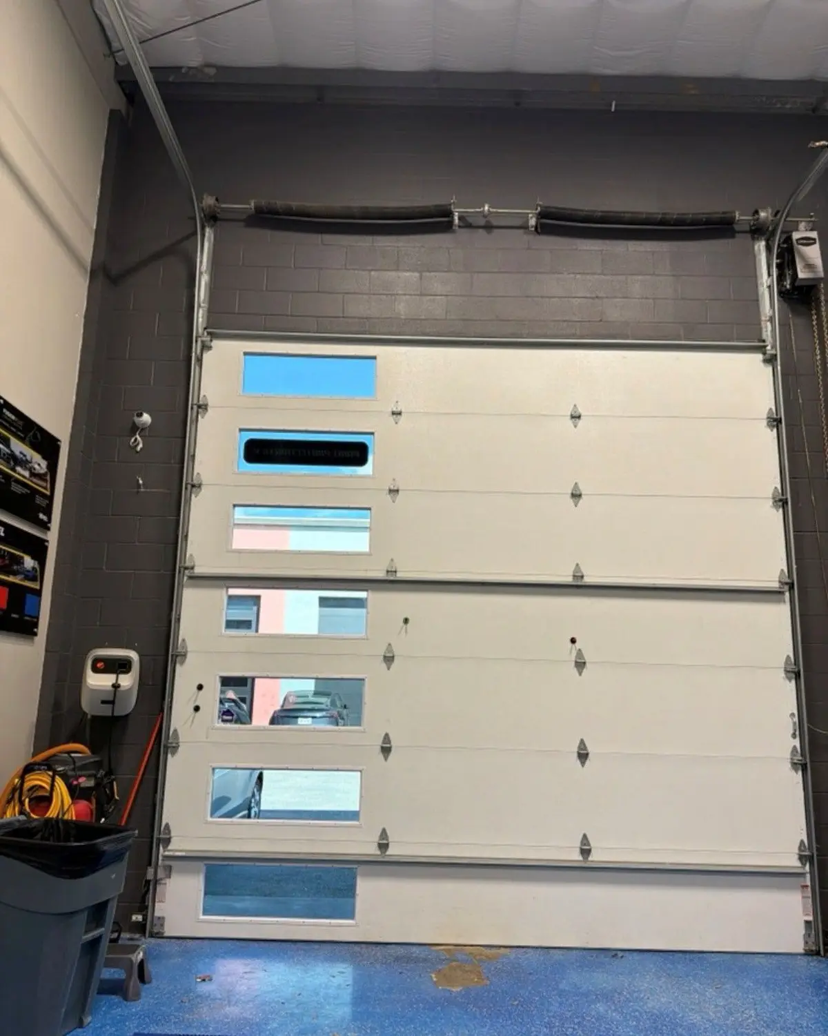 Tall sectional door with a column of window sections in a shop
