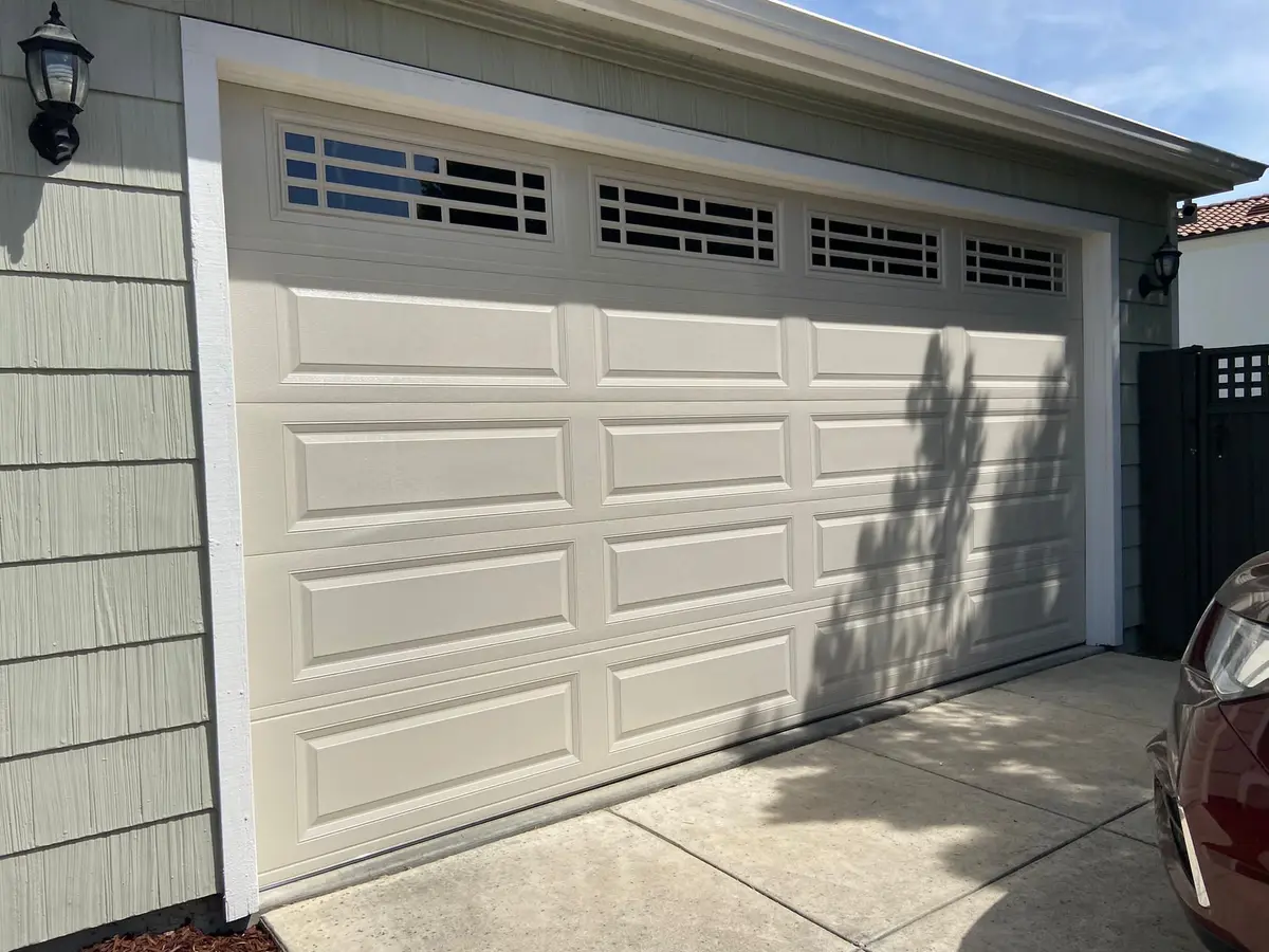 Almond raised panel garage door with a row of windows