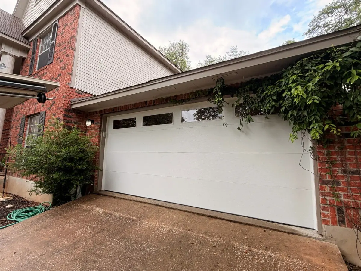 After: white flush panel garage door with top windows installed by Tier One in Austin 78759
