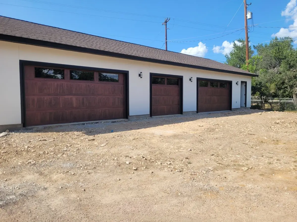Three wood tone garage doors on a new detached garage, installed by Tier One