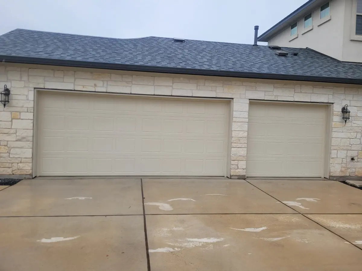 Almond double and single garage doors installed by Tier One on a limestone home