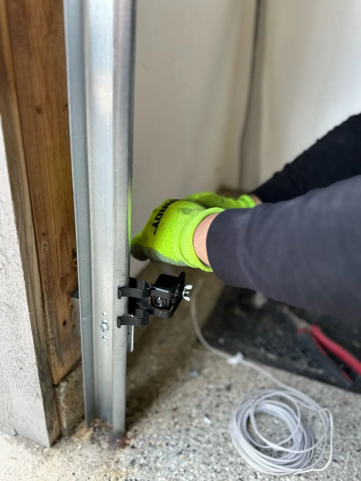 Garage door safety sensor being adjusted near the floor
