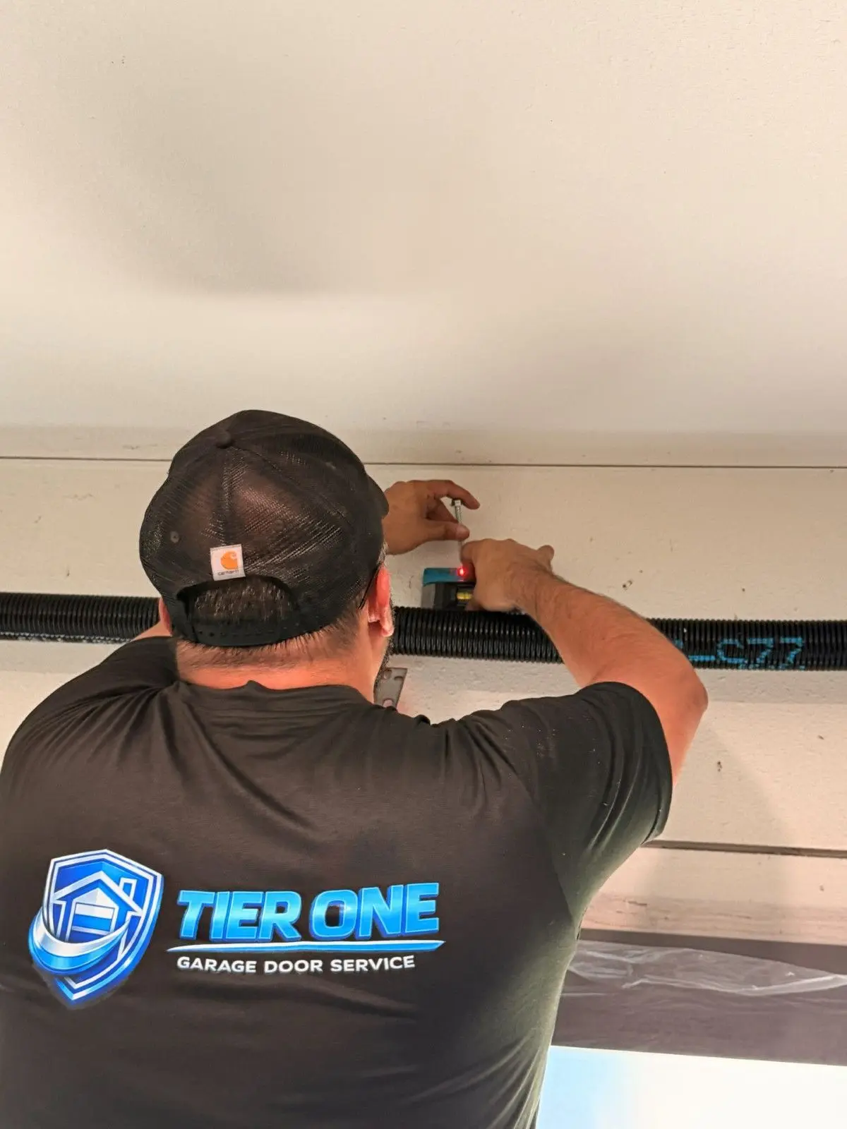Tier One technician installing a full view glass garage door