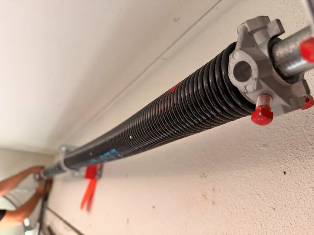 Torsion spring and winding cone on the shaft above a garage door